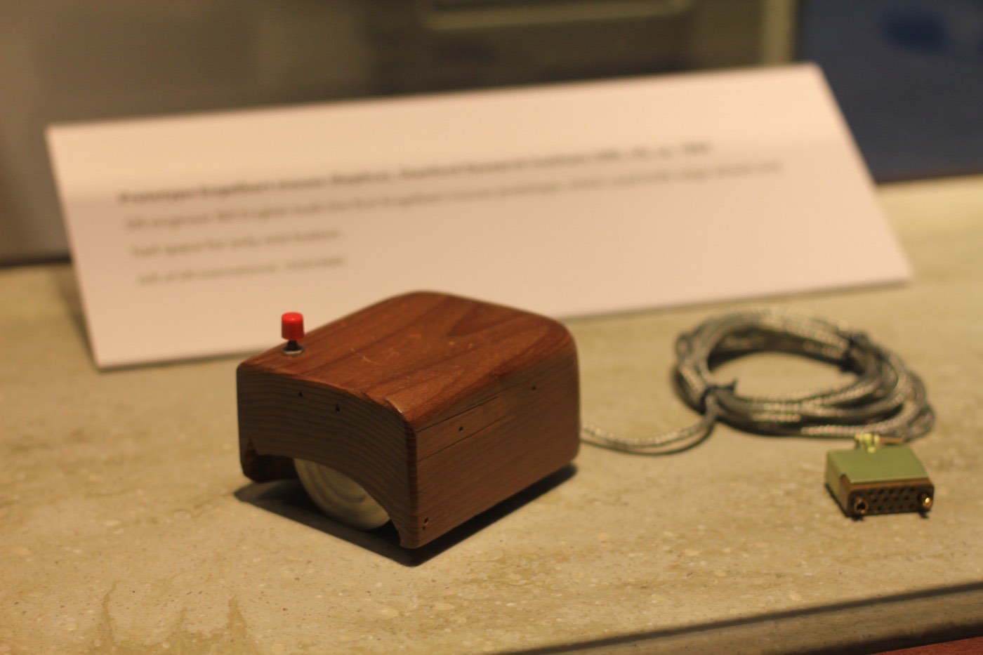 The first computer mouse: a small block of wood with two metal wheels and a single button, built for Engelbart's NLS.